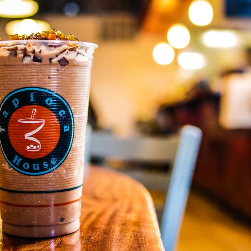 Chocolate tapioca drink with toppings on a wooden table at Tapioca House.