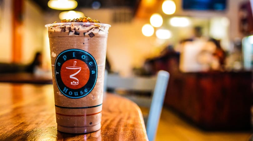 Chocolate tapioca drink with toppings on a wooden table at Tapioca House.